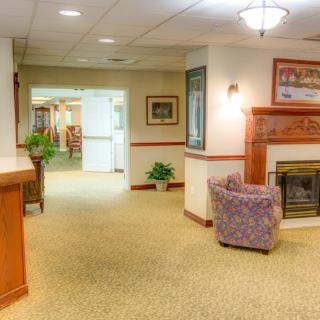 A cozy lobby area with a fireplace and comfortable seating leading into a hallway.