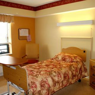 A cozy hospital room with a bed and basic amenities.