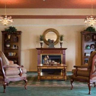 A cozy living room with elegant furniture, featuring a fireplace and two armchairs.