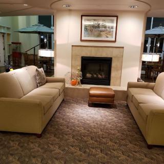 A cozy living room with two sofas facing each other, centered around a fireplace.