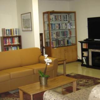 A cozy living room with a sofa, bookshelves, and a television.