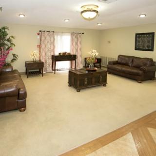 A spacious and inviting living room featuring leather sofas, a coffee table, and elegant decor.