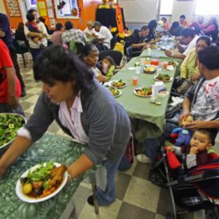 A community gathering where people are enjoying a meal together indoors.
