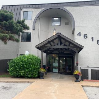 The entrance to a residential building with modern architecture and greenery.