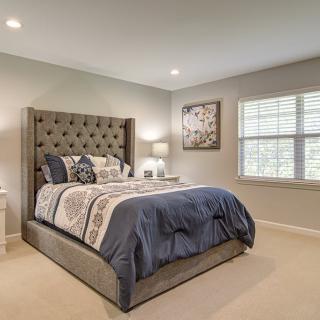 A modern bedroom with a plush, tufted headboard and elegant decor.