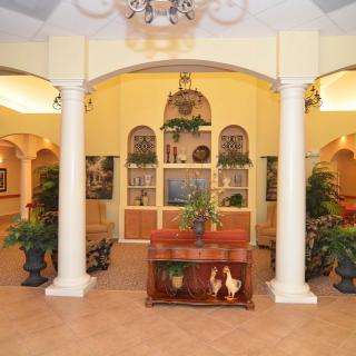A cozy interior space featuring elegant columns, decorative plants, and a welcoming ambiance.