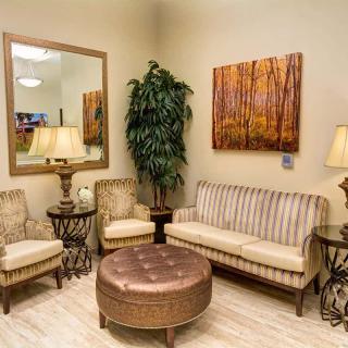 A cozy living room with comfortable seating, elegant lighting, and decorative art.