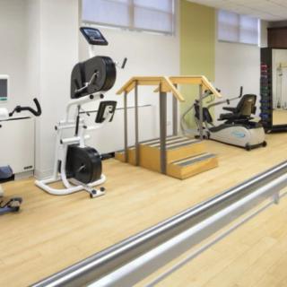 A rehabilitation gym with various exercise equipment for physical therapy.