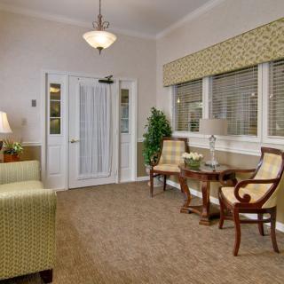 A cozy living room featuring elegant chairs, a small table, and soft lighting.