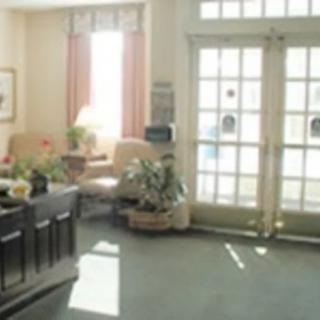 A cozy lobby area with seating, plants, and large windows letting in daylight.
