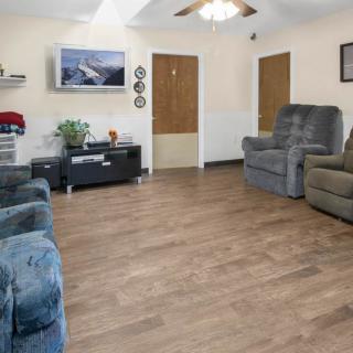A cozy living room with comfortable sofas, a television, and wood flooring.