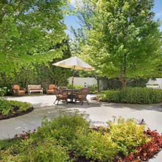 A serene garden patio with comfortable seating and lush greenery.