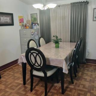 A cozy dining room with a large table and six chairs, adorned with a decorative plant centerpiece.