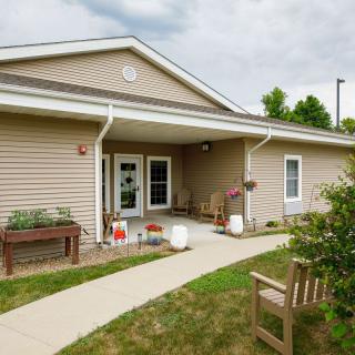 A small house with a porch and garden path leading to the entrance.
