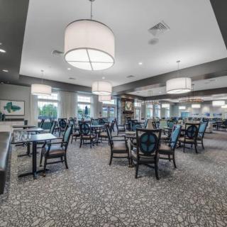 An elegantly designed dining area with modern lighting and neatly arranged tables and chairs.