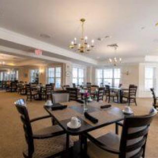 A spacious dining room with elegant lighting and neatly arranged tables.