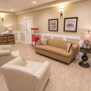 A cozy living room with elegant furniture and a popcorn machine.