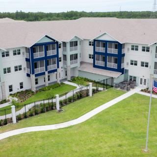 Aerial view of a modern residential apartment building with landscaped surroundings.