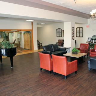 A cozy lounge area featuring comfortable seating, a piano, and stylish decor.