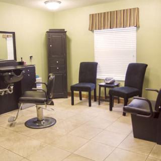 Cozy hair salon interior with a styling chair and seating area.