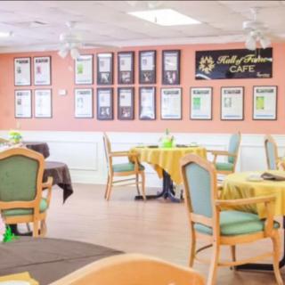 A cozy restaurant dining area with neatly arranged tables and chairs, decorated walls, and a menu board.