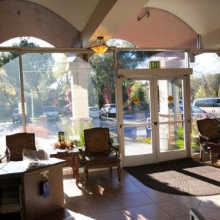 A sunlit waiting area with chairs and large windows.