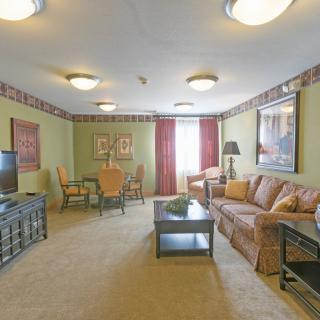 A well-furnished living room with a sofa, coffee table, and dining area.