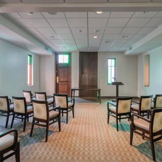 An empty chapel with arranged chairs and a podium.