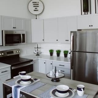 A modern kitchen with white cabinets and stainless steel appliances.