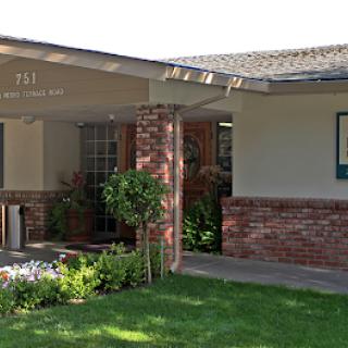 A charming residential home with a well-kept front yard and brick accents.