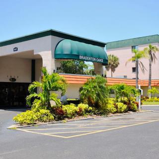 Hotel entrance with tropical landscaping and palm trees.