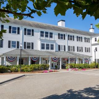 A large white hotel building with multiple windows and decorative patriotic bunting at the entrance.