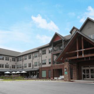 A modern residential building with a pitched roof and multiple windows on a clear day.