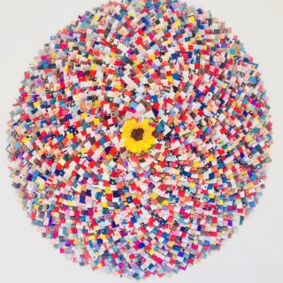 A vibrant circular pattern composed of colorful blocks surrounding a central yellow element.