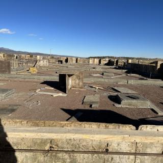 An expansive view of ancient stone ruins under a clear blue sky.