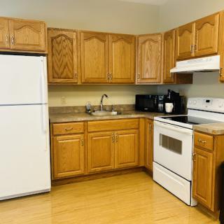 A cozy kitchen featuring wooden cabinets and essential appliances.