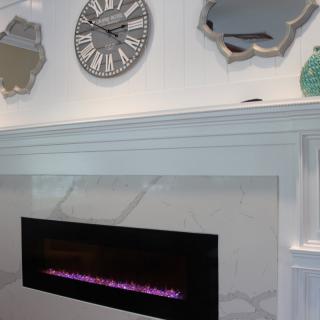 A modern interior with a sleek fireplace, decorative mirrors, and a stylish clock.
