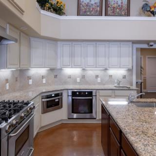 A modern kitchen with granite countertops and stainless steel appliances.