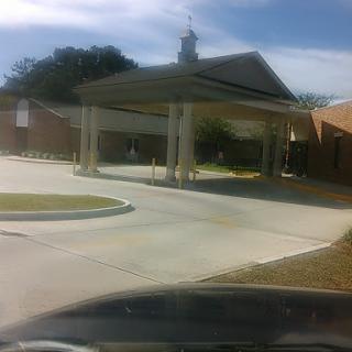 A view of a building with a covered entrance and a clear sky.