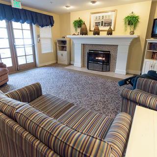 A cozy living room with a striped sofa and a fireplace.