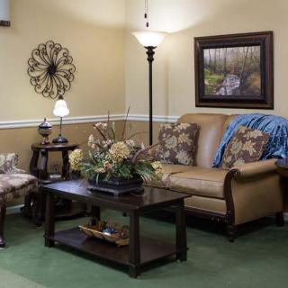 A cozy living room with a comfortable sofa, decorative cushions, and wall art creating a warm atmosphere.