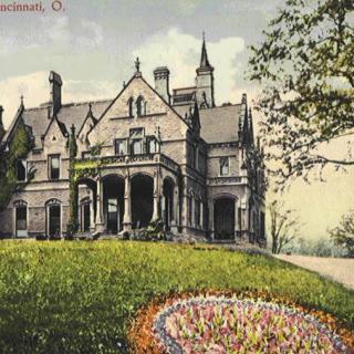 A historic Victorian-style mansion surrounded by a well-maintained garden.