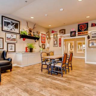 A cozy living room with various wall decorations, furniture, and wooden flooring.