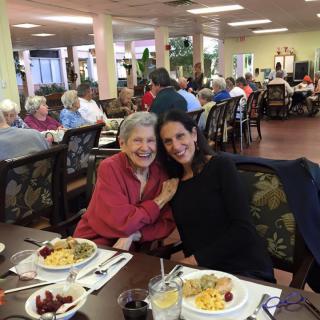 Two people enjoying a meal together in a busy dining hall.