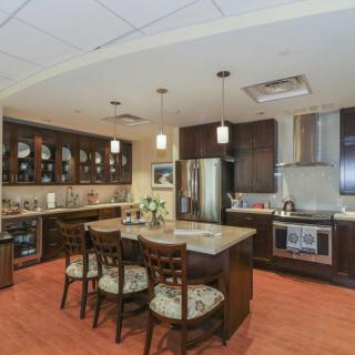 A modern kitchen featuring a central island with seating, pendant lighting, and stainless steel appliances.