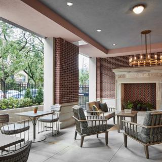 A modern outdoor patio with comfortable seating and a fireplace.