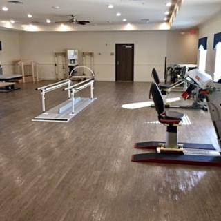 A spacious physical therapy gym equipped with exercise machines and rehabilitation tools.
