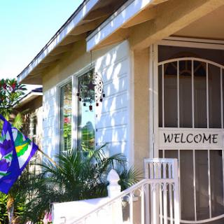 A welcoming entrance with a decorative flag and lush greenery.