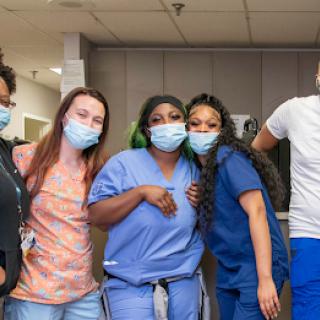 A group of healthcare professionals posing together in a hospital setting, showcasing their camaraderie and dedication.