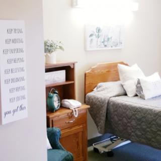 A cozy hospital room featuring a comfortable bed and inviting decor.